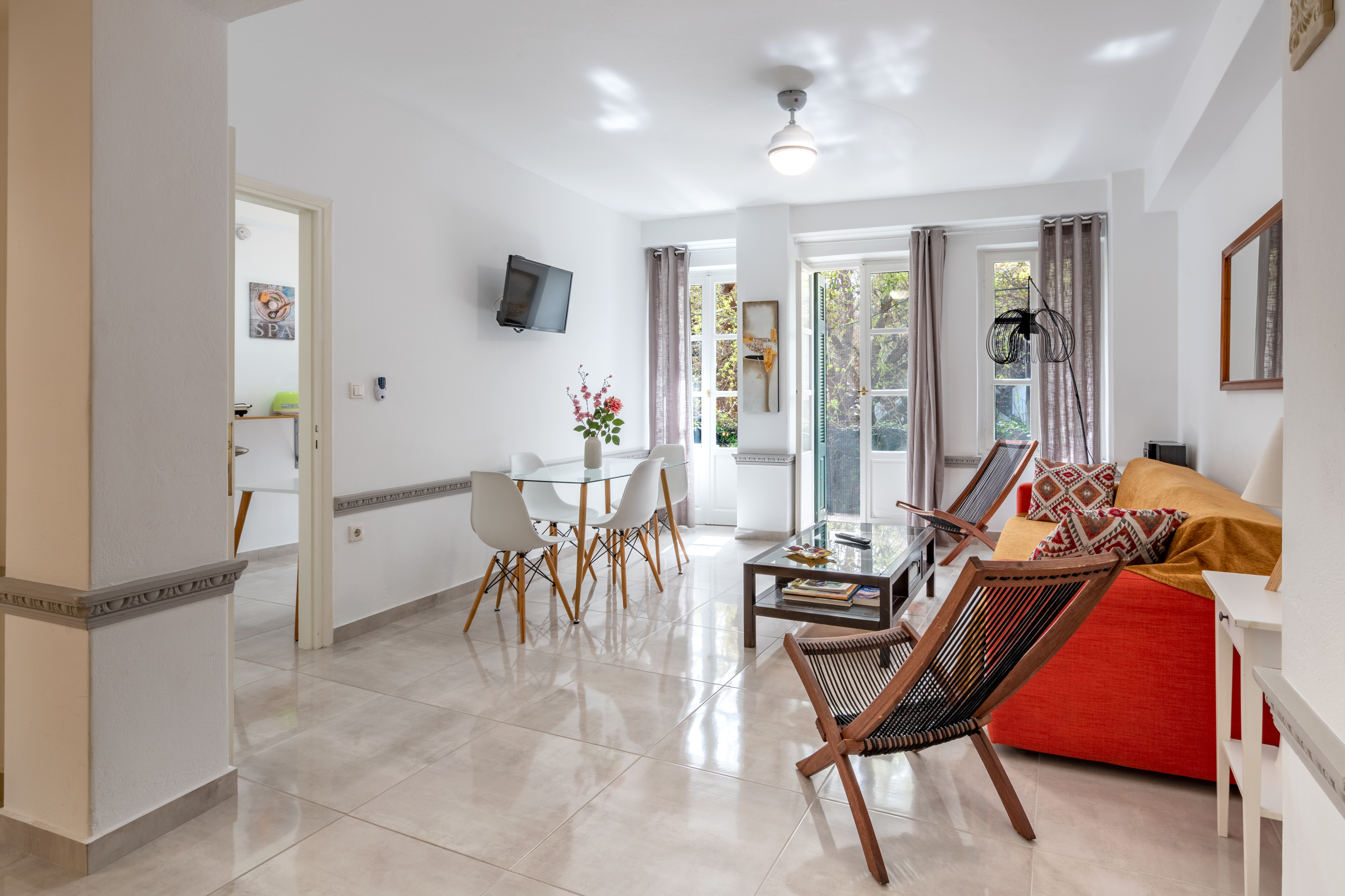 Living room with sofa, desk and dining table - Spacious and well-lit interior