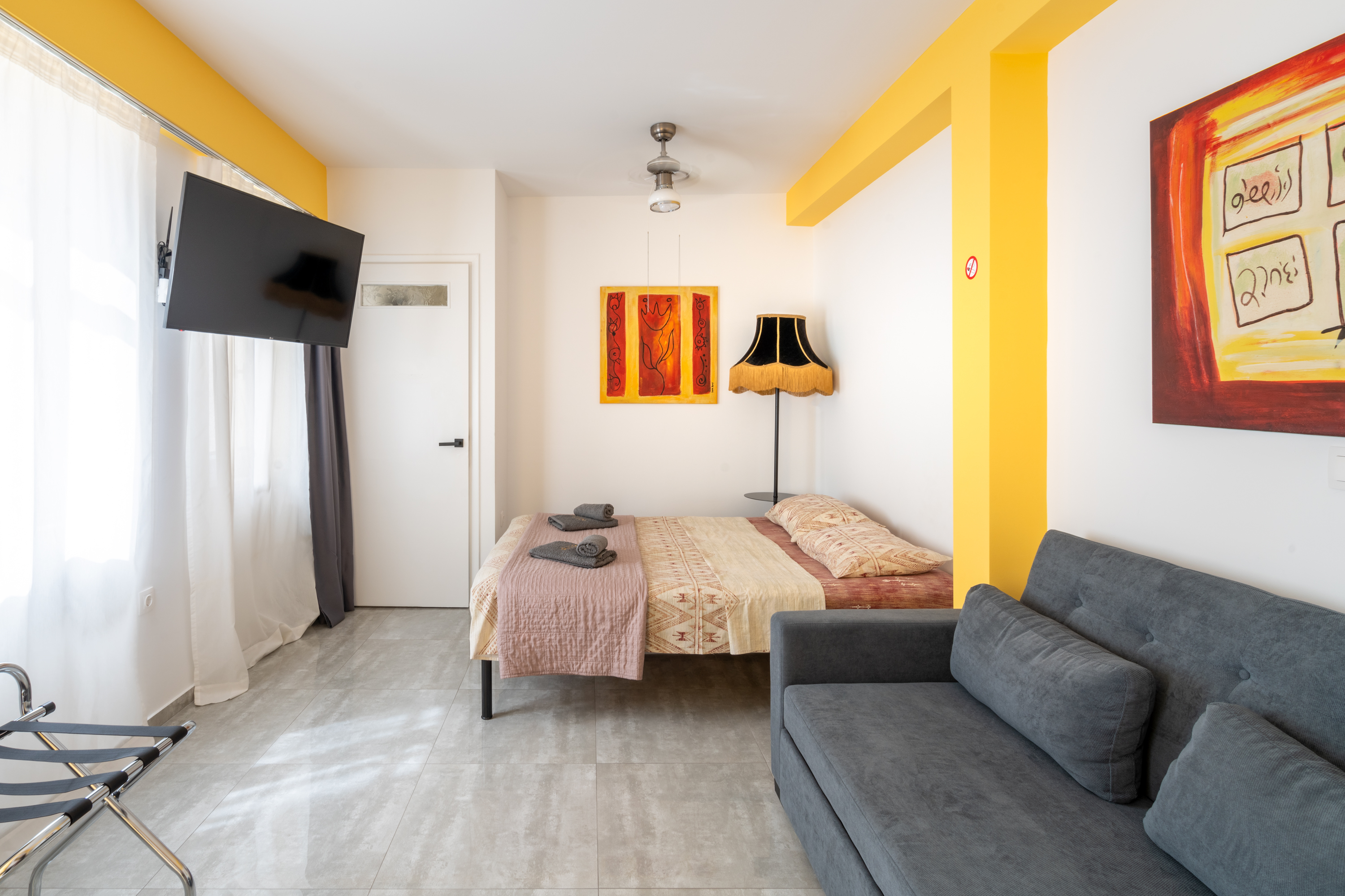 First floor studio with sofa, desk and open closet